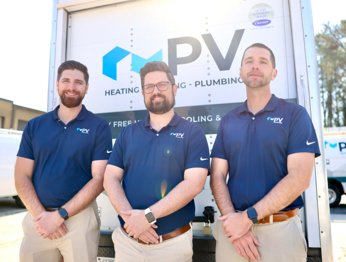 PV brothers posing for picture next to company truck